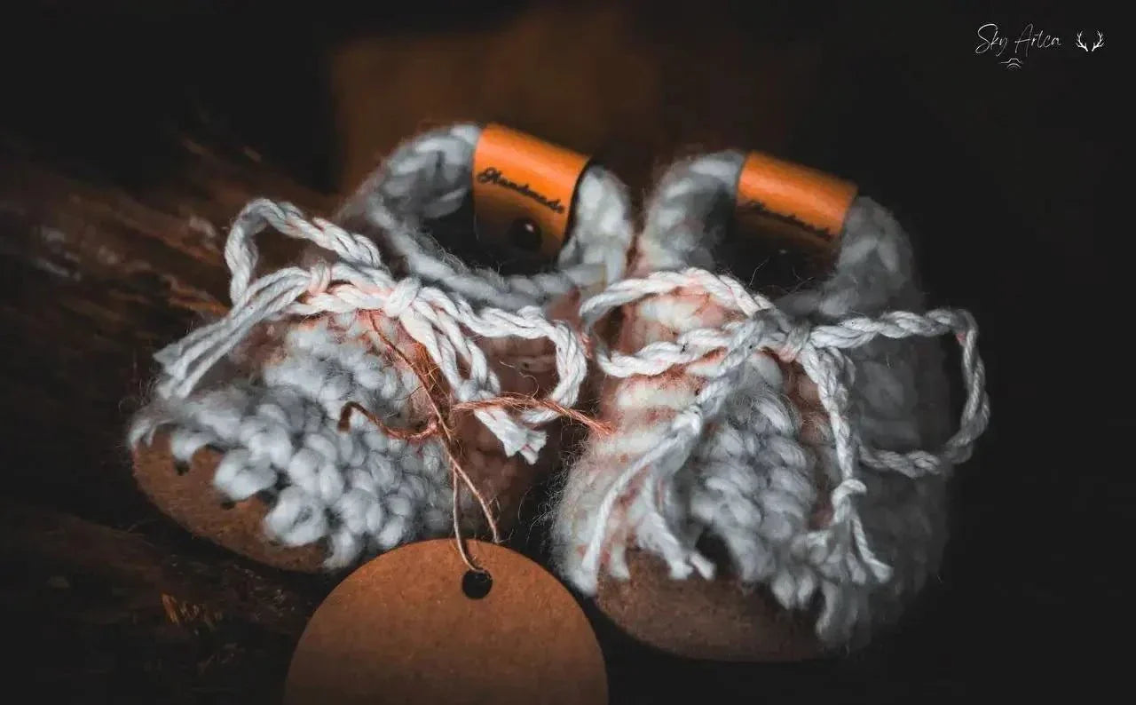 Chaussons bébé en laine naturelle modèle Loomi de Wilder Hat Co, couleur coton, avec intérieur douillet et semelle souple.