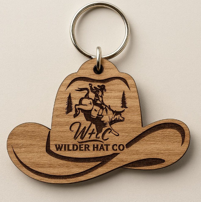 Porte-clé en bois artisanal de Wilder Hat Co, accessoire authentique avec gravure naturelle, posé sur une surface claire.